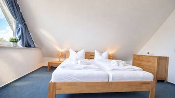 Ein Schlafzimmer mit einem hölzernen Bett, zwei Nachttischen, einer Kommode und einem Fenster mit Vorhängen.