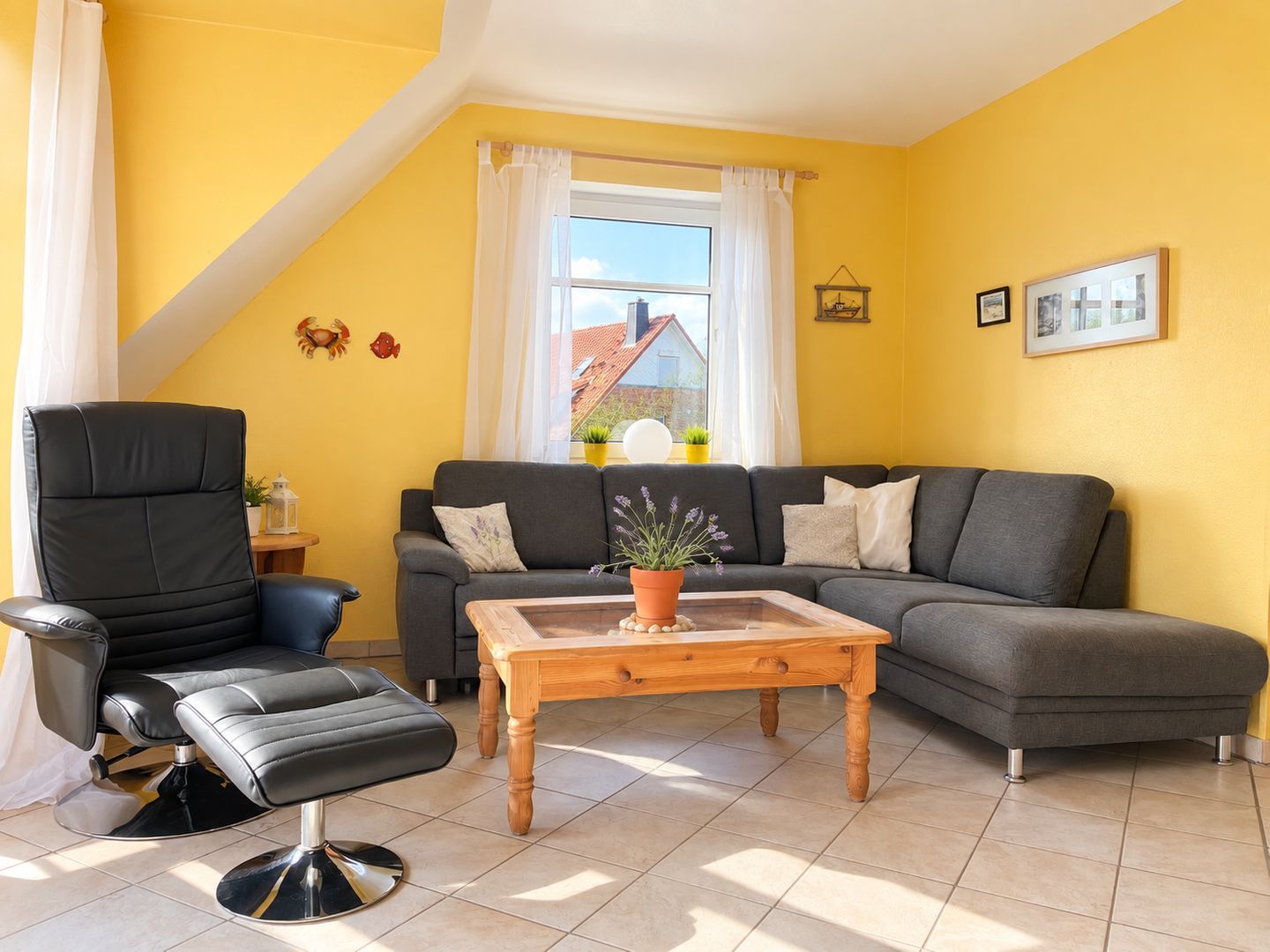 Ein Wohnzimmer mit einer Couch, einem Sessel, einem Couchtisch und einem Fenster mit Vorhängen.