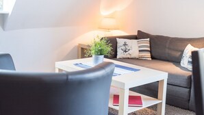 Ett mysigt vardagsrum med en soffa, ett soffbord och en lampa.