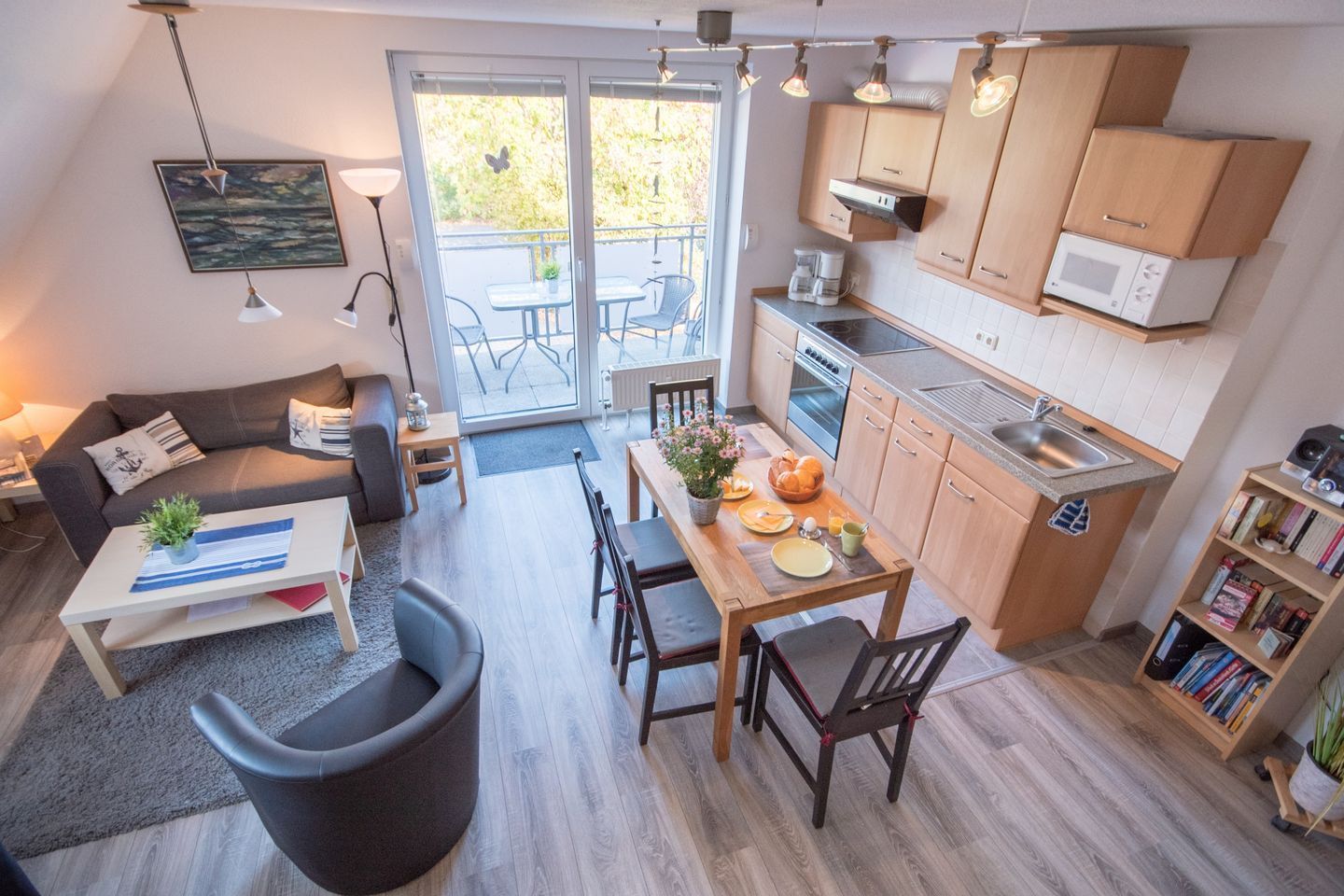 A compact living space with a dining area, kitchenette, and a sofa with a coffee table.