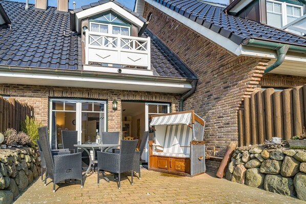 Une maison dotée d’un patio, d’un espace salon extérieur et d’une terrasse en bois.