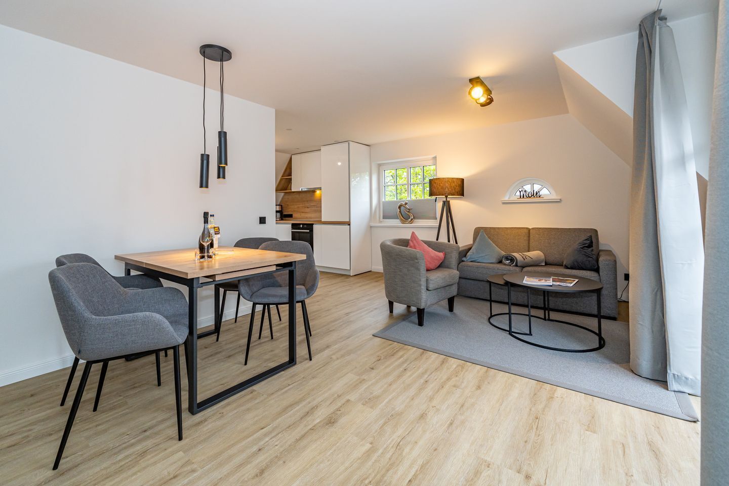 A modern living room with a dining area, a sofa, and a coffee table.