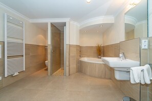 Un baño moderno con ducha, bañera y lavamanos.
