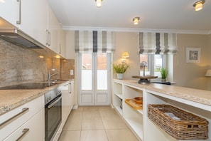 A modern kitchen with granite countertops, stainless steel appliances, and a central island.