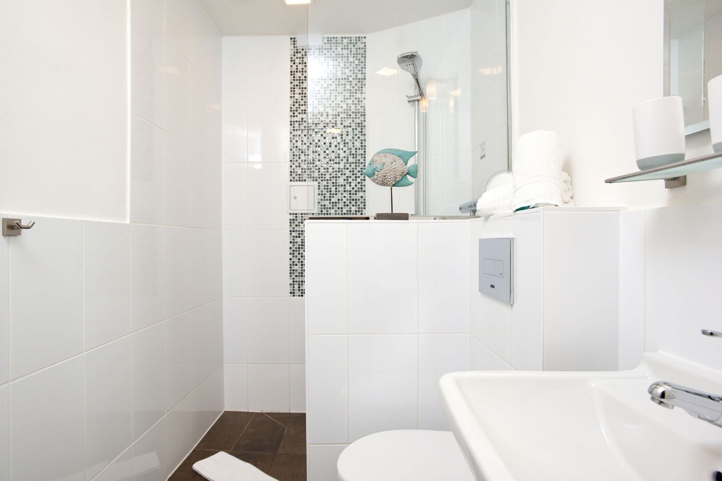 Ein modernes Badezimmer mit Dusche, Toilette und Waschbecken.
