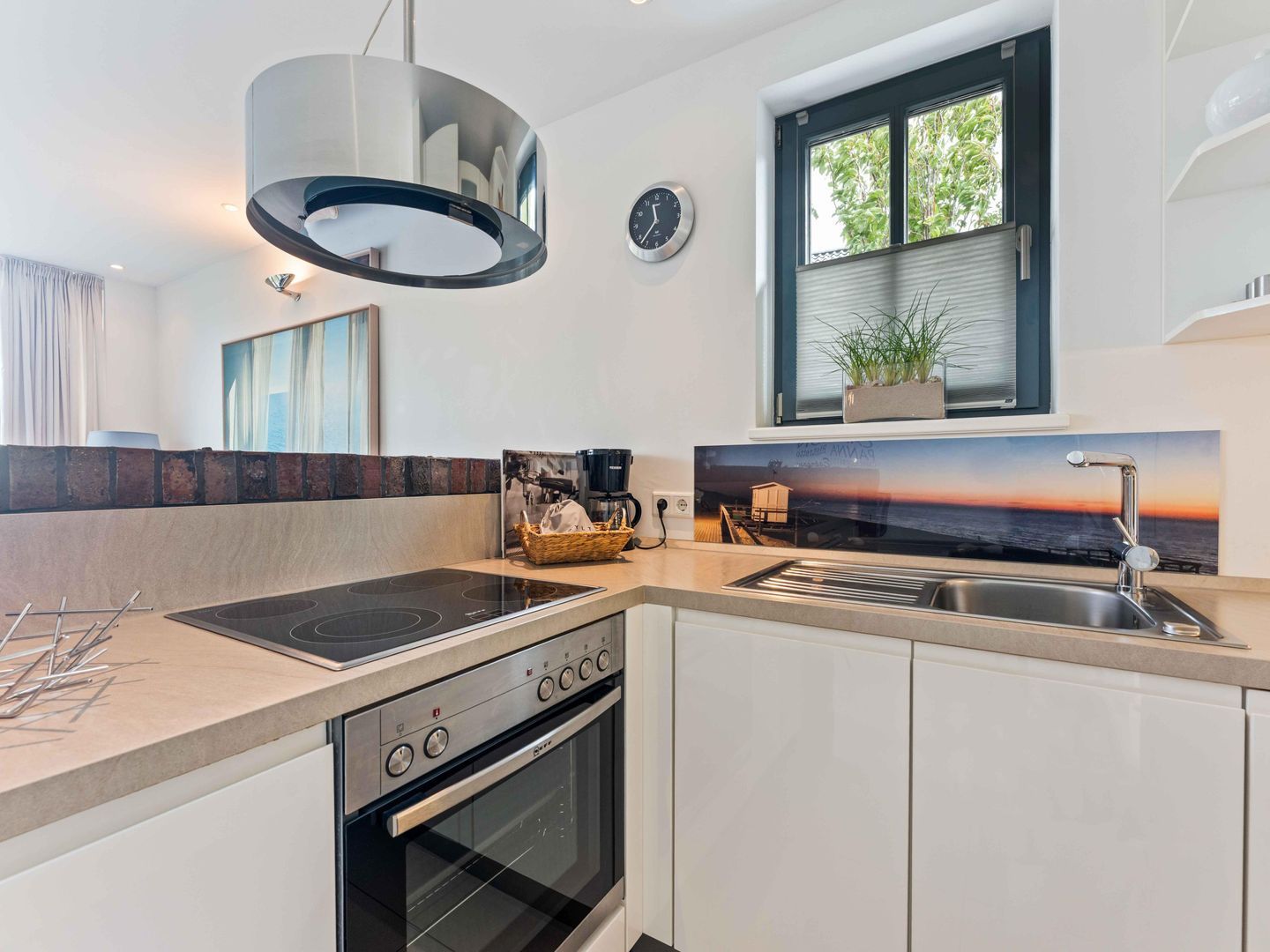 A modern kitchen with a built-in stove, oven, and sink.