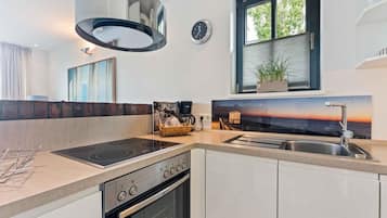 A modern kitchen with a built-in stove, oven, and sink.