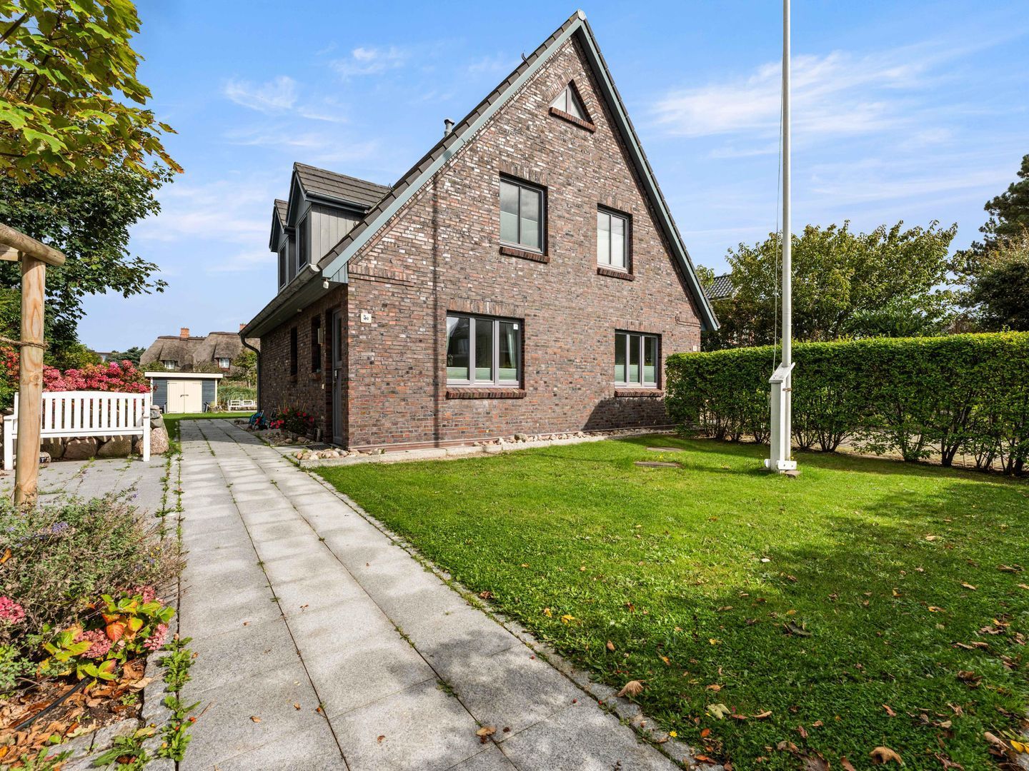 A modern two-story house with a brick exterior, a visible garage, and a well-maintained lawn.