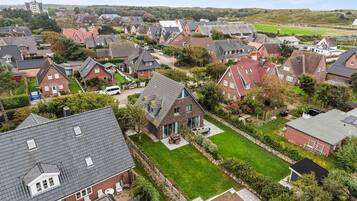 Et boligområde med huse, en græsplæne og en bygning i det fjerne.
