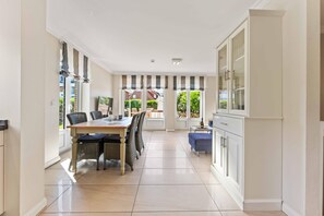 Una cocina moderna con comedor, ventanas amplias y vistas al exterior.