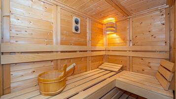 Eine Sauna mit Holzbänken und einem Holzfass.