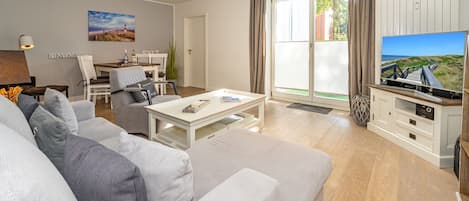 A modern living room with a sofa, coffee table, and a TV stand with a flat-screen TV.