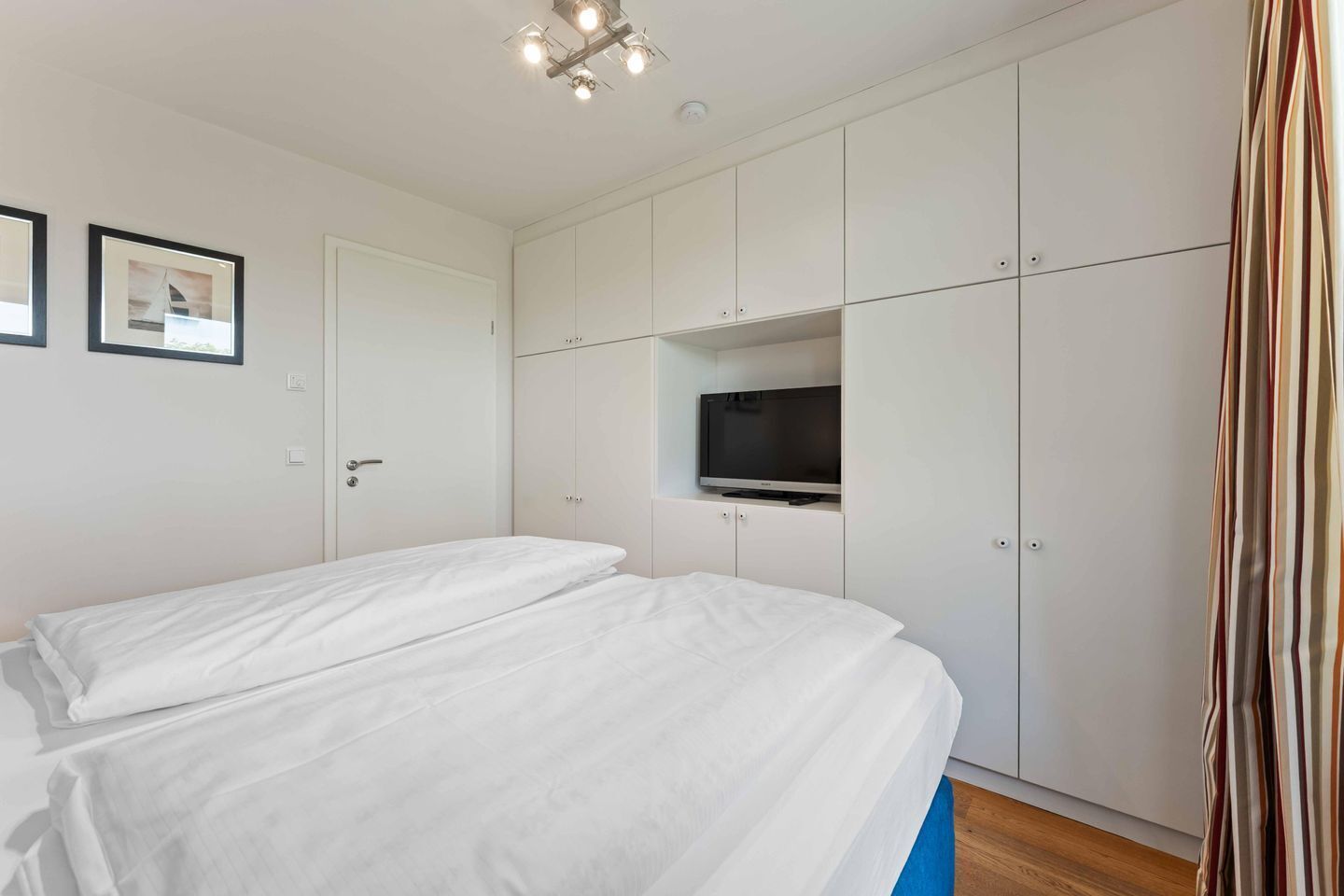 Une chambre d’hôtel avec deux lits, une télévision et une armoire.