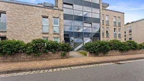 A modern building with a brick facade, large windows, and a staircase leading to an upper level. - Beach Suite, App. 2 - Nah am Meer- Sand im Haar und Salz in der Luft (Sylt)