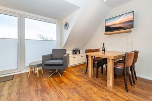 Quarto de estilo loft moderno, com um amplo claraboia, mesa de jantar de madeira e um espaço de estar aconchegante.