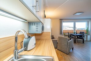 A modern kitchen with a built-in stove, a sink, and a dining area with a table and chairs.