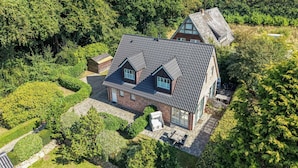 A house with a sloped roof, a brick exterior, and a paved patio with outdoor furniture. - Wandaful Hüs - Holiday home for max. 4 persons, in a quiet location with (Sylt)
