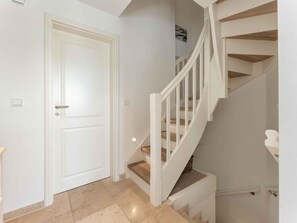 A white interior with a door and a staircase. - Syltmuschel - Relaxen Sie in der Wunderschönen und Neuen 3-zimmerwohnung in Westerland (Sylt)