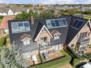 A residential building with multiple skylights, a brick facade, and a small balcony.
