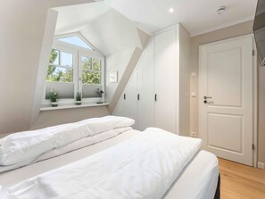 Une chambre à coucher avec un lit, une fenêtre et une porte.