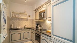 A kitchen with a tiled backsplash, a coffee maker, and a microwave. - App. Störtebeker App. 16 - Close to the beach & right in the city center. Vacation apartment for (Sylt)