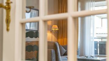 Une chambre d’hôtel avec un canapé, une table avec des verres et une lampe.