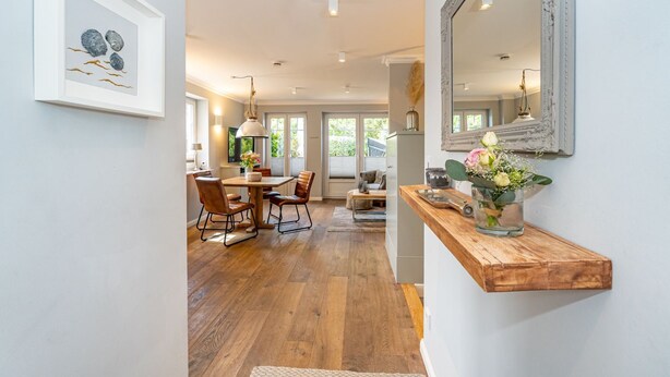 Un grand espace dédié à la salle à manger, avec une table et des chaises en bois, un banc en bois et un miroir au mur.