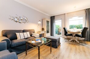 Ein modernes Wohnzimmer mit einer Couch, einem Couchtisch und einem Essbereich.