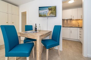 A modern kitchen with white cabinets and stainless steel appliances.