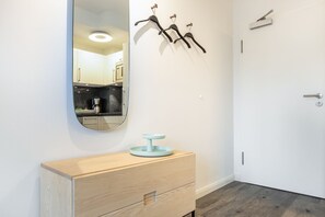 A modern bathroom with a wooden vanity, a round mirror, and a light blue sink.