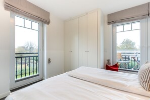 Une chambre à coucher avec un lit, une armoire et un balcon offrant une vue.