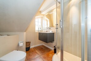 Un baño moderno con ducha, inodoro y lavabo.