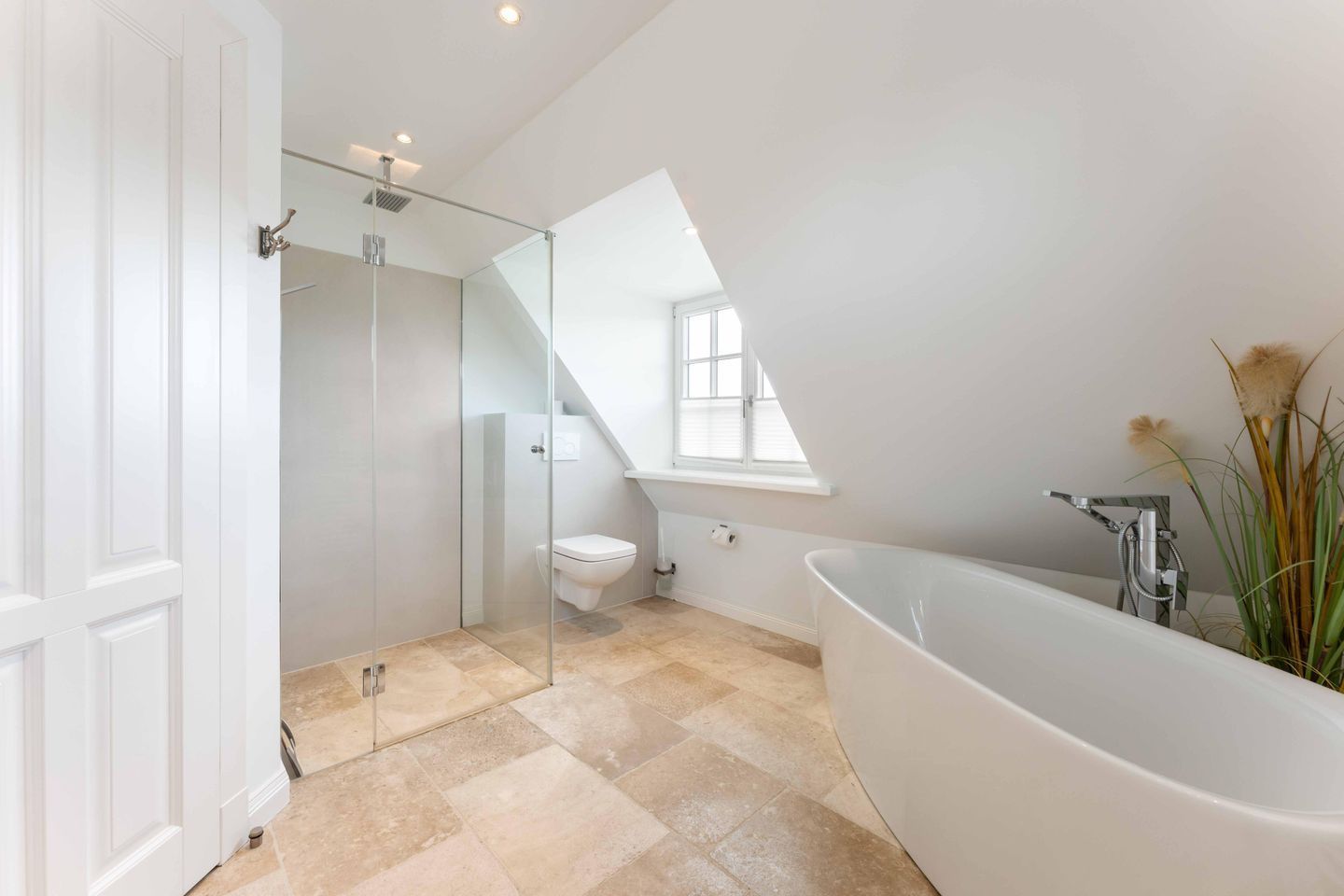 Un baño moderno con una bañera independiente, cabina de ducha con mampara de vidrio y un inodoro.