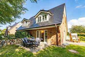 A house with a patio, a dining table, and chairs. - Sylt Oase - semi-detached vacation home for max. 6 persons with sauna, garden and (Sylt)