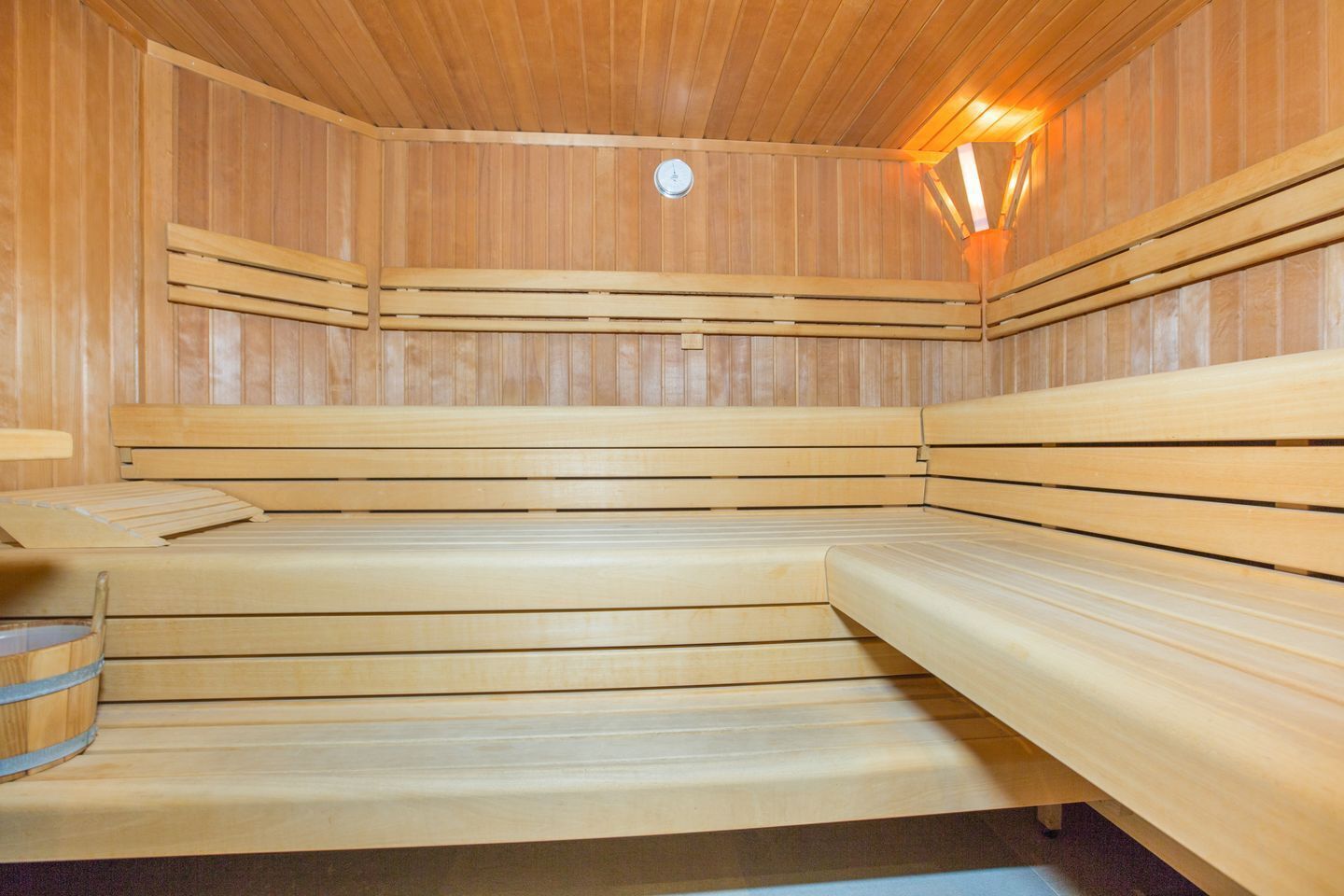 A sauna with wooden benches and a bench with a towel.
