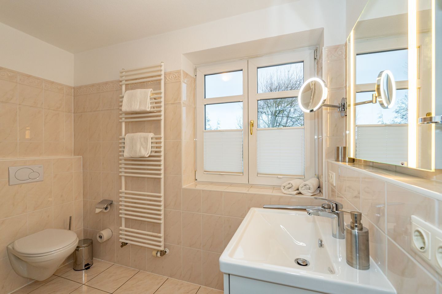Une salle de bain moderne équipée de toilettes, d’un lavabo et d’un porte-serviettes.
