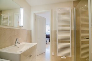 Une salle de bain moderne avec un lavabo, un miroir et des porte-serviettes.