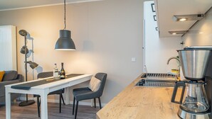 Eine moderne Küche mit Holzarbeitsplatte, einer Kaffeemaschine und einem Essbereich mit Tisch und Stühlen.