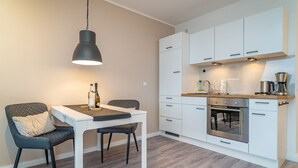 Eine moderne Küche mit weißen Schränken, einem Einbauofen und einer Kaffeemaschine.