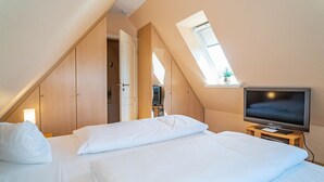 A bedroom with a bed, a television, and a window. - Ammerland Whg. 2 - Spacious 3-room apartment for up to 4 persons, with balcony. (Sylt)