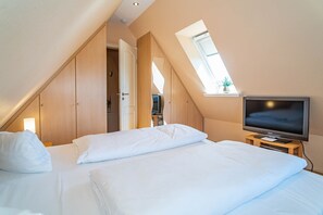 A bedroom with a bed, a television, and a window. - Ammerland Whg. 2 - Spacious 3-room apartment for up to 4 persons, with balcony. (Sylt)