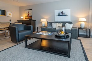 A modern living room with a sofa, a coffee table, and two side tables with lamps.