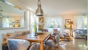 A dining area with a wooden table, leather chairs, and a hanging light fixture.