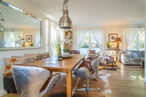 Un comedor con una mesa de madera, sillas de cuero y una lámpara colgante.