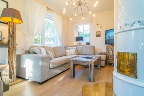 A living room with a sofa, coffee table, and a fireplace. - Maarwiet Hüs - Vacation home (single-family home) for up to 6 people with a garden and (Wenningstedt-Braderup (Sylt))