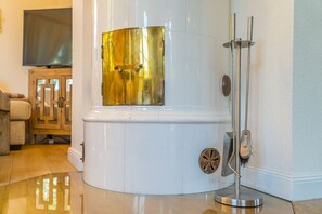 Un sauna moderne et compact, doté d’une section avec des tubes dorés, d’une douche à vapeur et d’un support en métal.