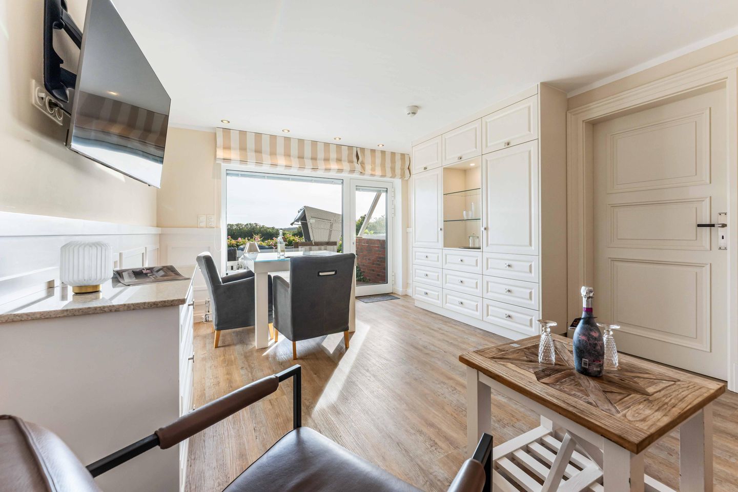 A modern kitchen with a dining area, a large window, and a view of the outdoors.