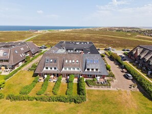 A large, modern building with multiple roof levels and a spacious courtyard.