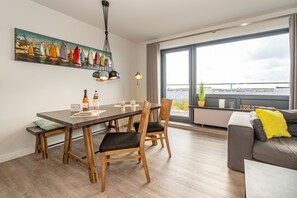 Una sala de estar moderna con comedor, ventanas amplias y vista al agua.