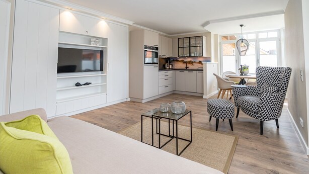 Un salon moderne avec un canapé, une table basse et un fauteuil à motifs.